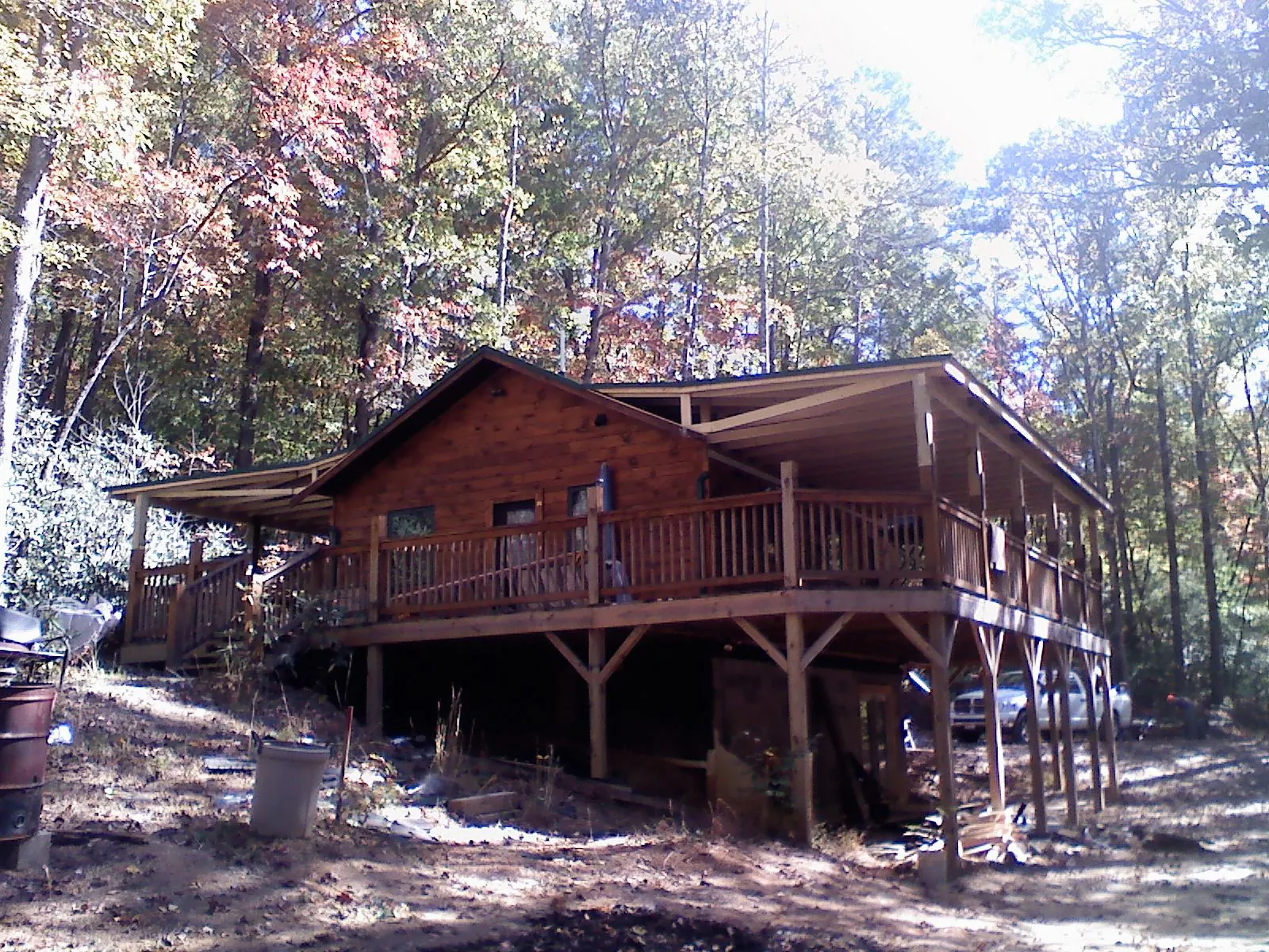 Log cabin with a wraparound porch and metal roof in the fall in Fremont